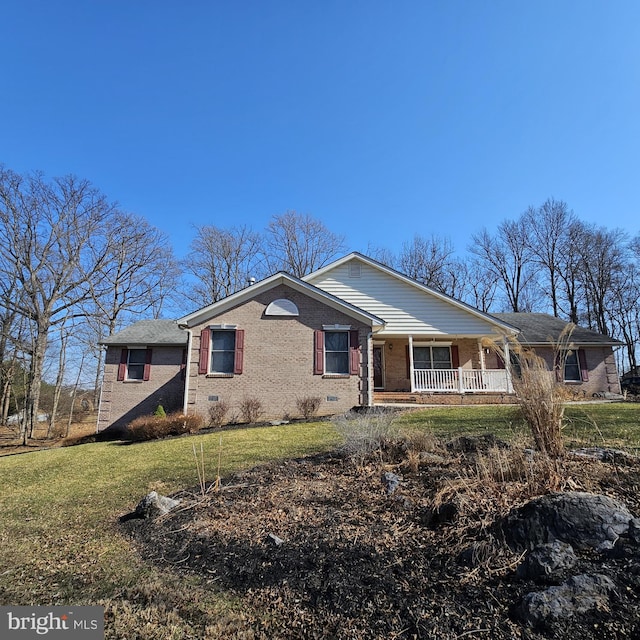 ranch-style home featuring a front yard, brick siding, and covered porch