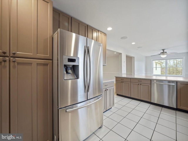 kitchen with light tile patterned floors, ceiling fan, light countertops, and appliances with stainless steel finishes