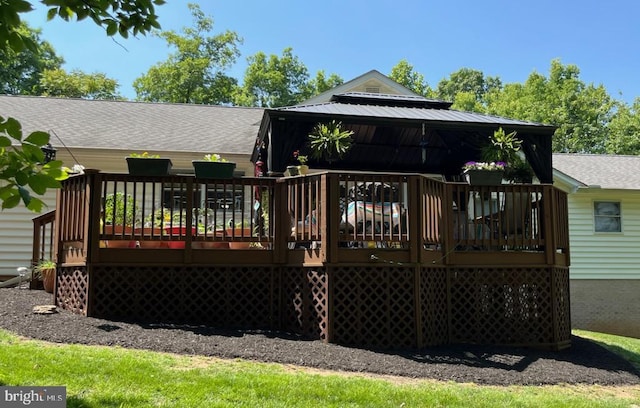 rear view of property featuring a wooden deck and roof with shingles