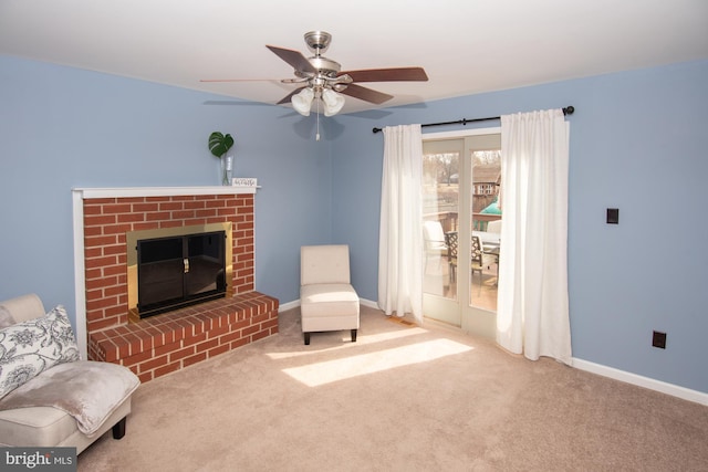 sitting room with baseboards, carpet floors, a brick fireplace, and ceiling fan