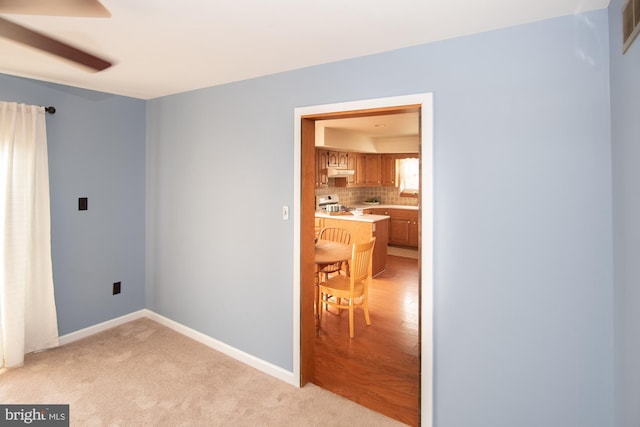 empty room featuring light carpet, visible vents, and baseboards