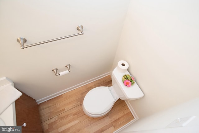 bathroom featuring toilet, wood finished floors, and baseboards