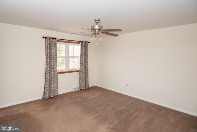 spare room with visible vents, a ceiling fan, baseboards, and carpet floors