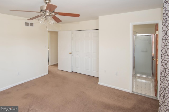 unfurnished bedroom featuring visible vents, ensuite bathroom, a closet, carpet, and baseboards