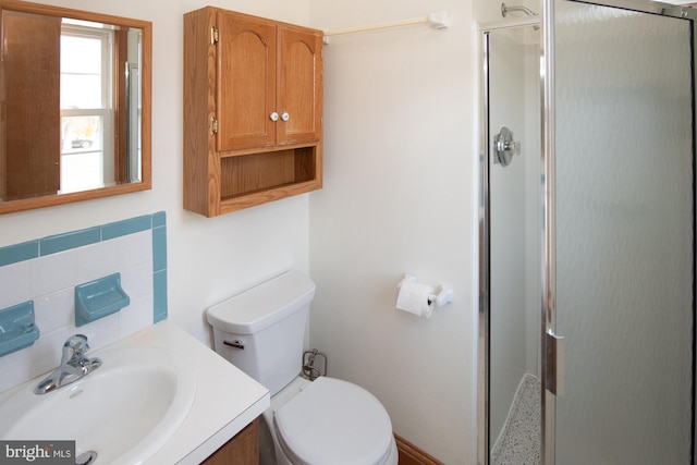 bathroom with backsplash, vanity, toilet, and a shower stall