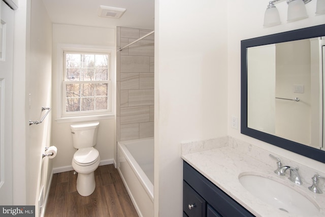 bathroom featuring toilet, vanity, baseboards, and wood finished floors