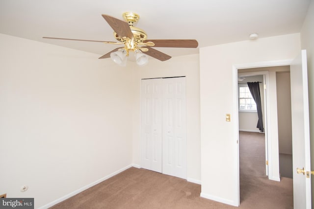 unfurnished bedroom with carpet flooring, baseboards, and a closet