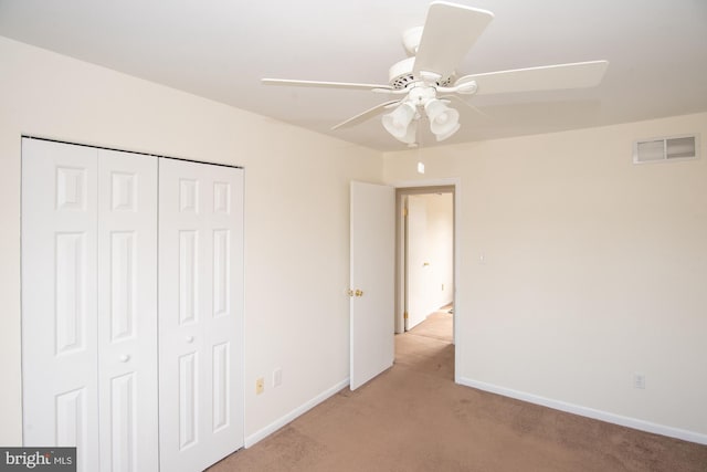 unfurnished bedroom with visible vents, baseboards, ceiling fan, light colored carpet, and a closet