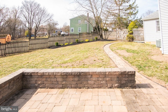 view of yard with a gate, cooling unit, a fenced backyard, and a patio