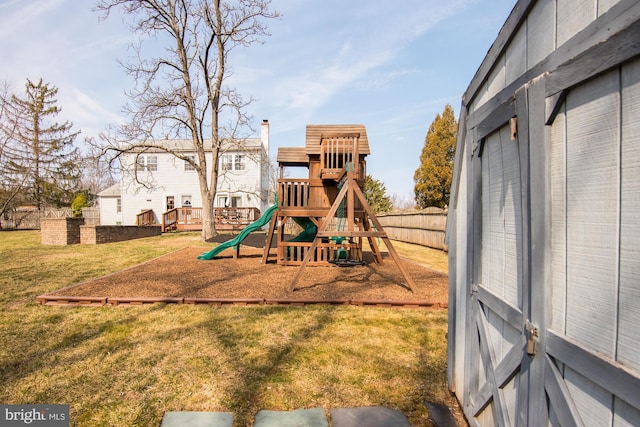 view of playground featuring a lawn and fence