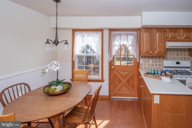 dining space with light wood-style floors and a wainscoted wall