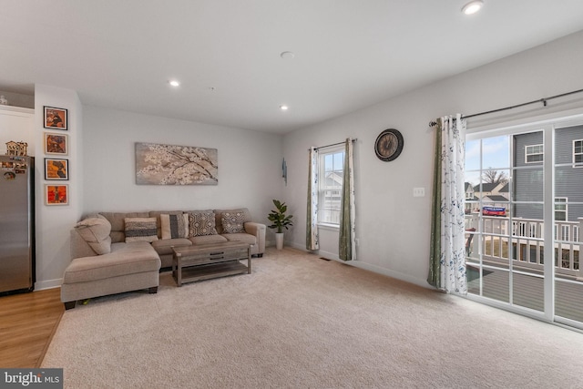 carpeted living room with recessed lighting and baseboards