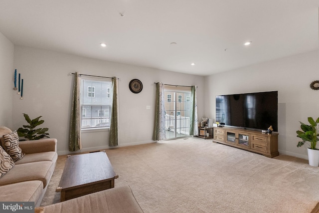 carpeted living area with recessed lighting and baseboards