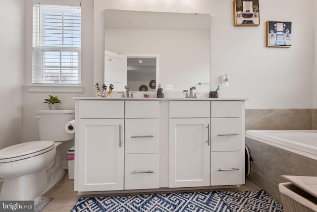 full bath with tile patterned floors, toilet, a sink, double vanity, and tiled tub