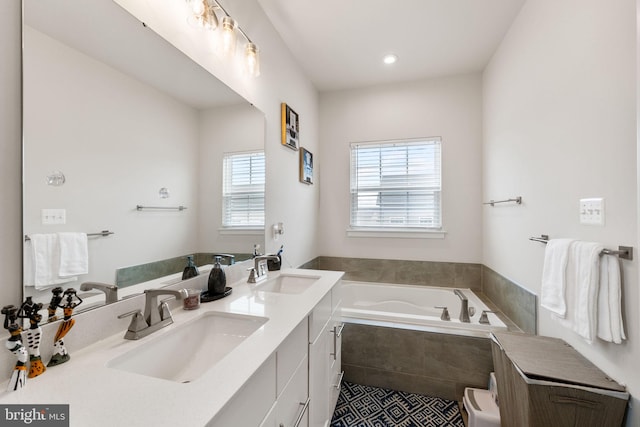 full bath with a sink, a garden tub, and double vanity