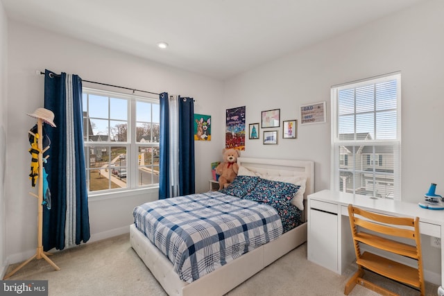 bedroom with light colored carpet and baseboards