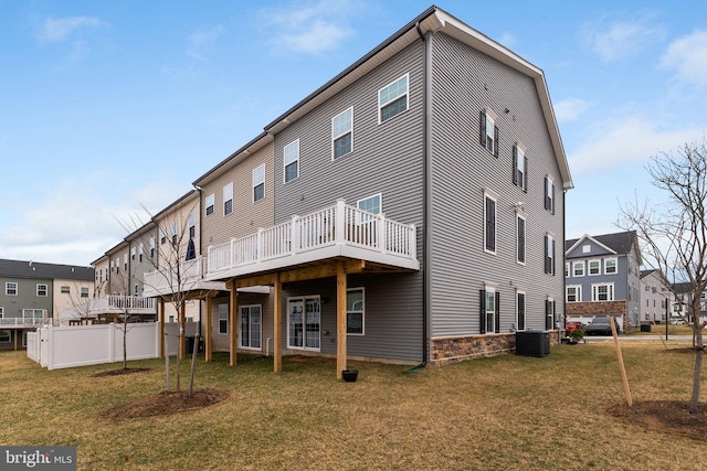 back of house with central AC unit, a lawn, fence, and a wooden deck