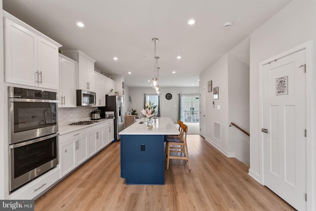 kitchen featuring white cabinetry, a kitchen island with sink, visible vents, and stainless steel appliances