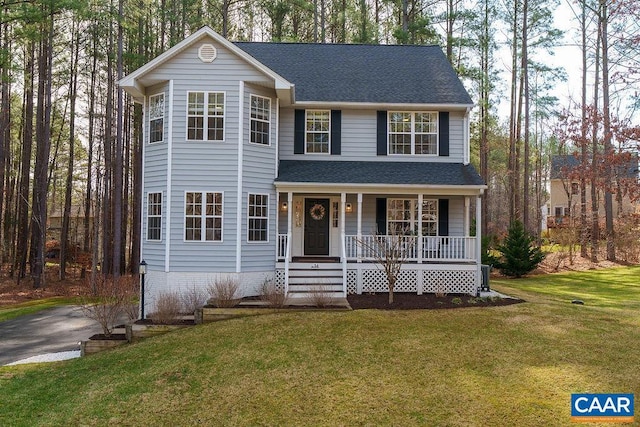 view of front facade with a porch, a front yard, and roof with shingles