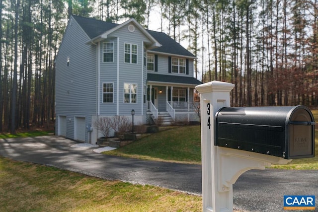 view of front of home with a front yard, an attached garage, and driveway