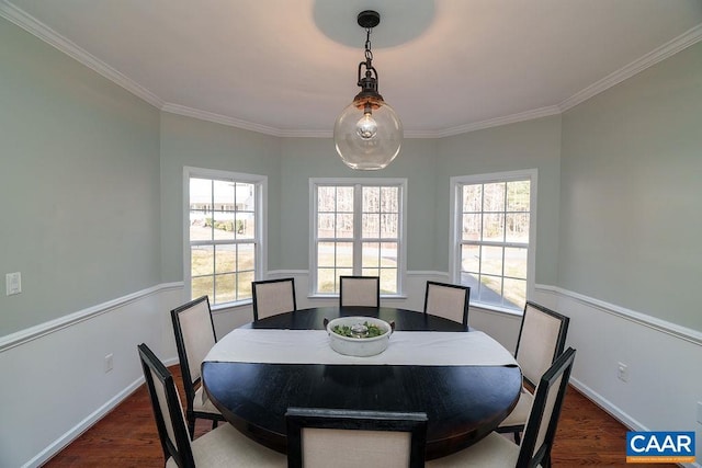 dining space featuring crown molding, baseboards, and wood finished floors