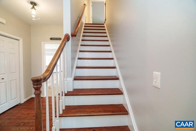 staircase with baseboards and wood finished floors