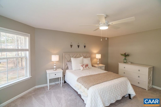 bedroom with light colored carpet, a ceiling fan, and baseboards