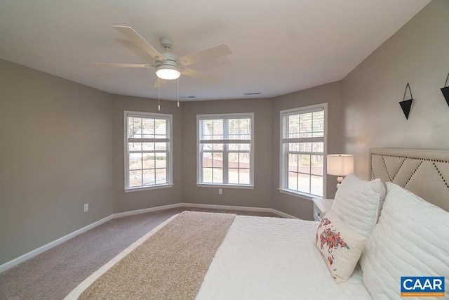 carpeted bedroom with visible vents, baseboards, and ceiling fan