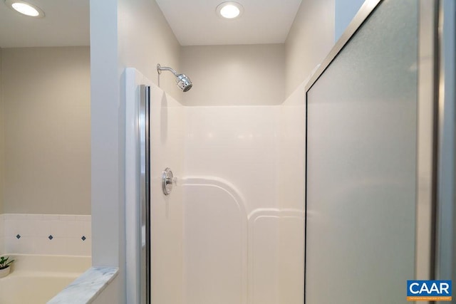 full bathroom with recessed lighting, a garden tub, and a stall shower