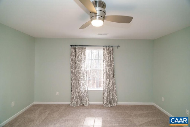 carpeted empty room featuring visible vents, baseboards, and ceiling fan