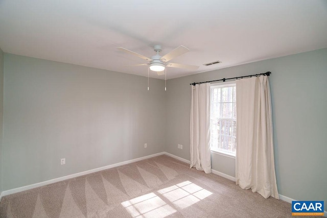 spare room featuring visible vents, baseboards, light colored carpet, and a ceiling fan