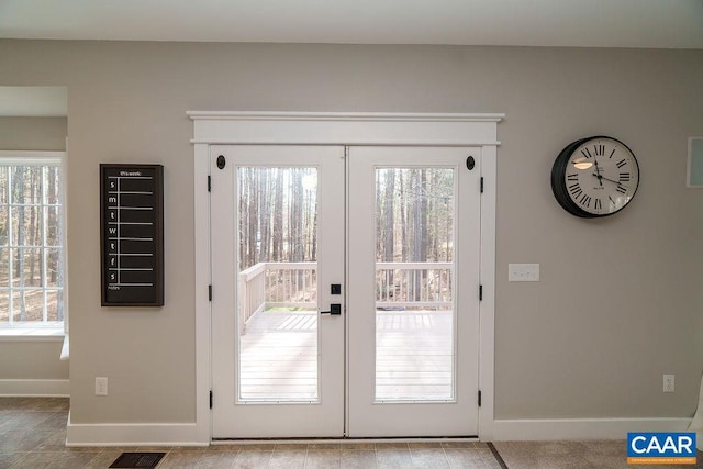 doorway to outside with plenty of natural light, french doors, and baseboards