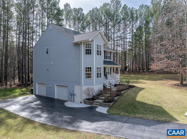 view of home's exterior with a yard, driveway, covered porch, and an attached garage