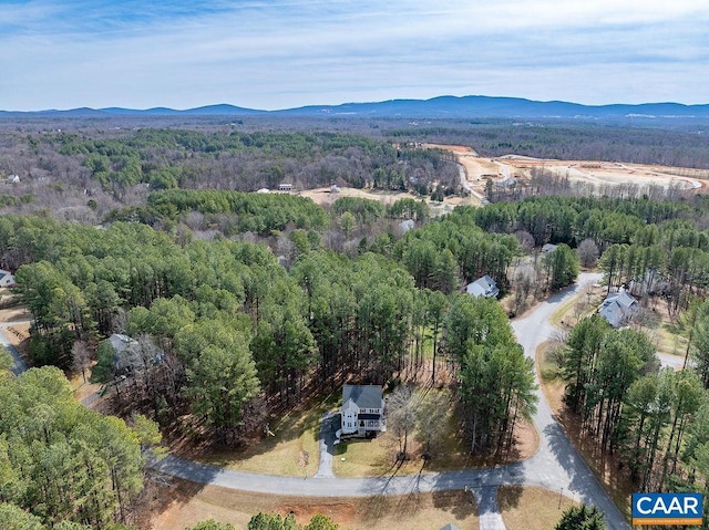 drone / aerial view with a mountain view and a forest view