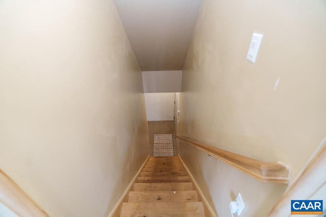 staircase with wood finished floors and baseboards