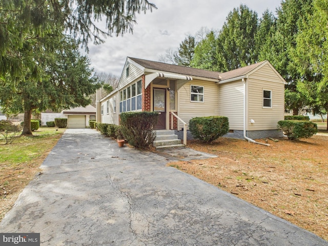 view of front facade with crawl space, a detached garage, and an outdoor structure