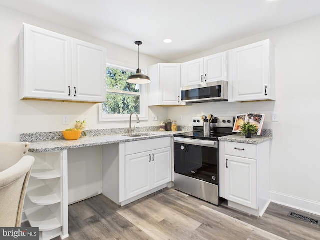 kitchen featuring light wood-type flooring, a sink, open shelves, appliances with stainless steel finishes, and white cabinets