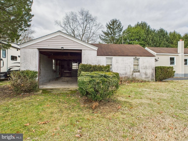 exterior space with a front yard, an outbuilding, and stucco siding