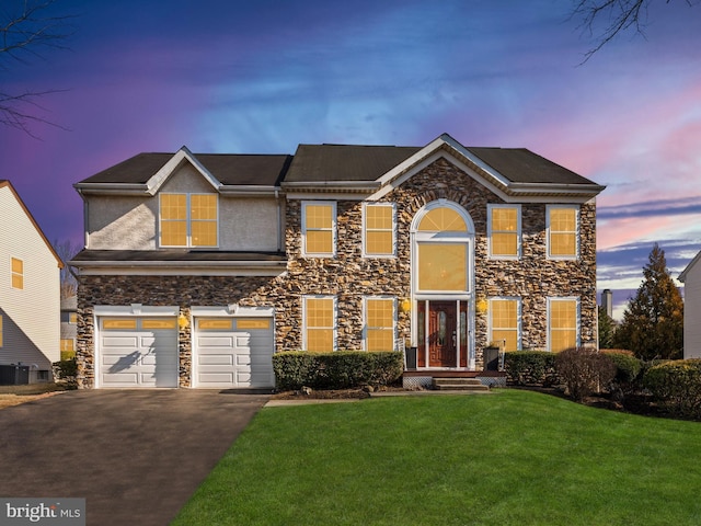 view of front of house featuring a yard, an attached garage, driveway, and stucco siding