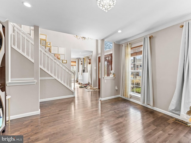 entrance foyer featuring stairs, wood finished floors, baseboards, and ornamental molding