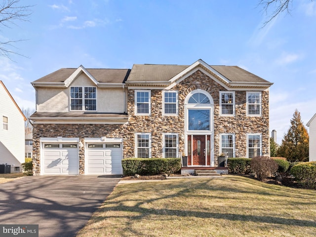 view of front of house featuring aphalt driveway, an attached garage, a front lawn, and stucco siding