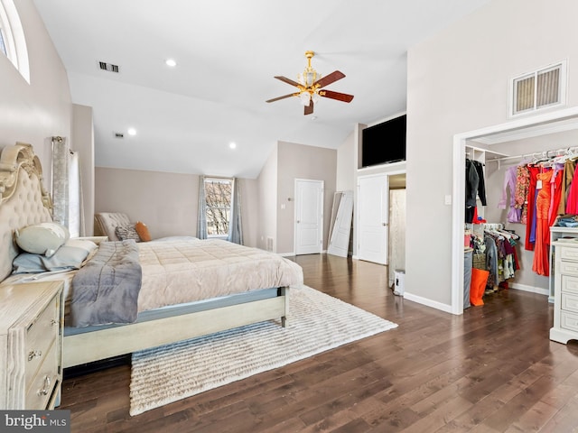 bedroom with visible vents, baseboards, a walk in closet, and dark wood-style floors