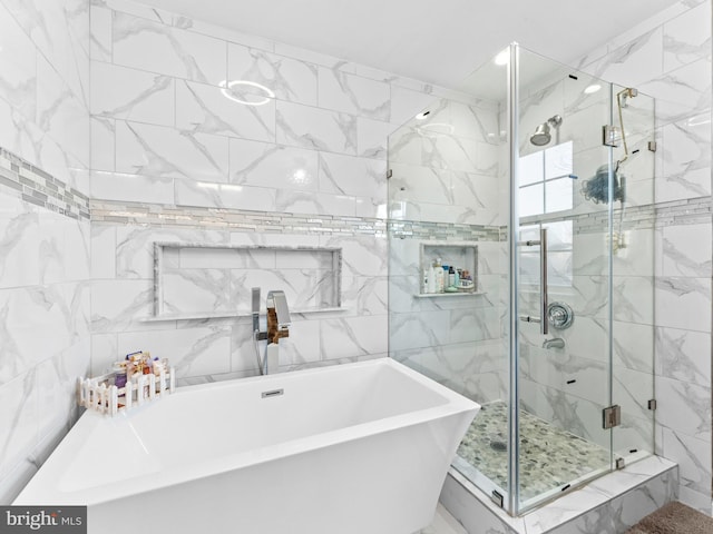 bathroom featuring a freestanding bath, tile walls, and a stall shower