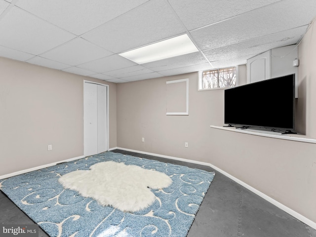 interior space with baseboards and a drop ceiling