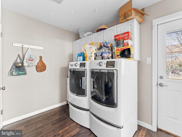 clothes washing area featuring baseboards, cabinet space, washing machine and dryer, and dark wood finished floors