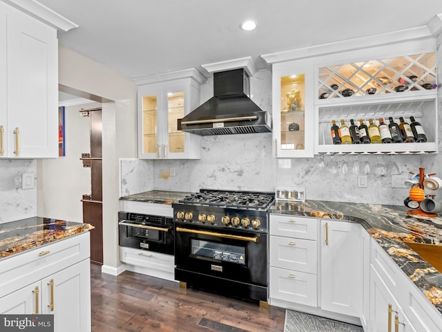 kitchen featuring dark stone countertops, black appliances, wall chimney exhaust hood, and white cabinetry