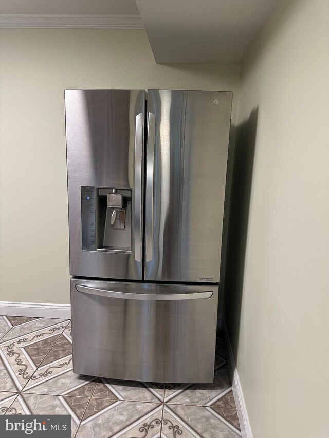 interior details with crown molding, stainless steel fridge with ice dispenser, and baseboards