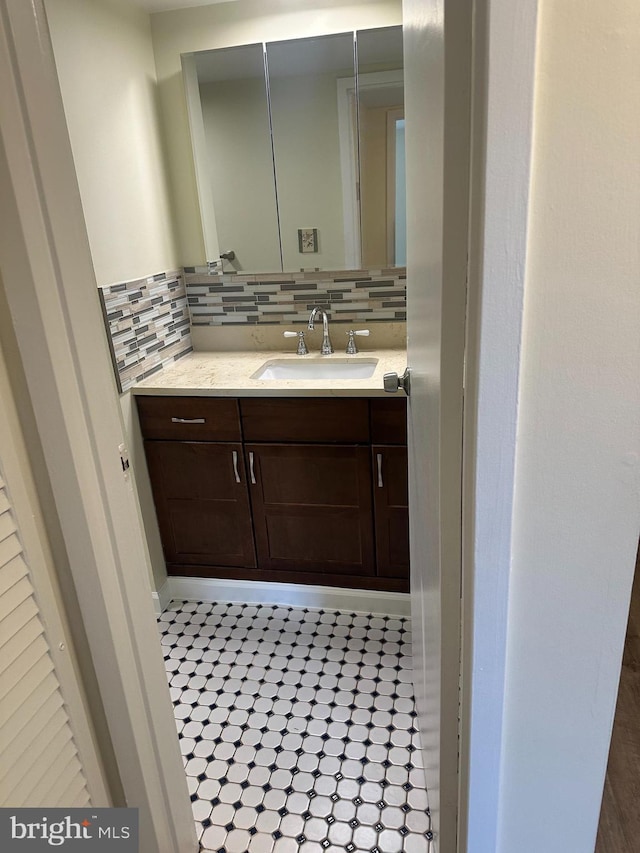 bathroom with tasteful backsplash, tile patterned floors, and vanity