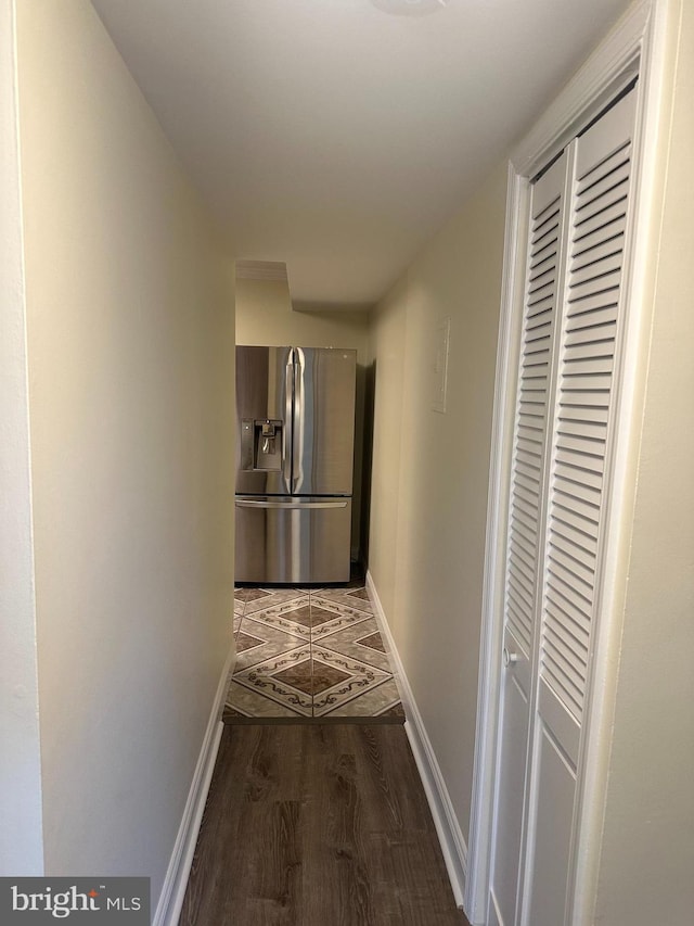 hall featuring baseboards and wood finished floors