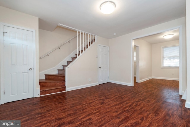 interior space with stairs, wood finished floors, and baseboards